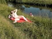'Riverside naked milf sunbathing is not shy about random fisher. Outdoors. Wild beach. Public nudity'