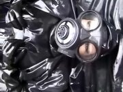 'Latex girl full in black rubber and Gasmask chill outs outdoor in garden in a heavy rubber hammock'